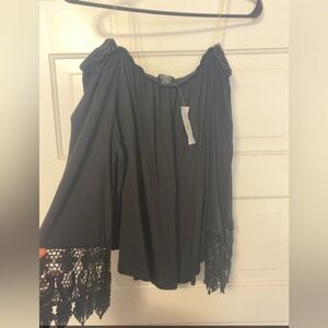 Off the shoulder, flowy shirt with wide detailed sleeves.